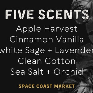 Puede incluir: Gr&aacute;fico en blanco y negro con el texto "FIVE SCENTS" en una fuente desgastada. El texto "Apple Harvest", "Cinnamon Vanilla", "white Sage + Lavender", "Clean Cotton" y "Sea Salt + Orchid" se enumera a continuaci&oacute;n. El texto "SPACE COAST MARKET" est&aacute; en la parte inferior en dorado.