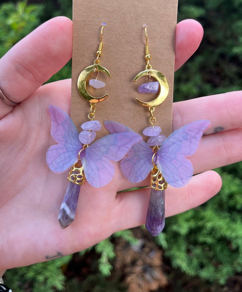 May include: Purple butterfly earrings with gold crescent moon charms and amethyst crystal drops.