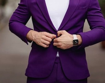 May include: A man wearing a purple suit jacket and matching trousers. He is wearing a white t-shirt underneath the jacket and a white watch on his left wrist.