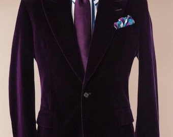 May include: A purple velvet blazer with a single button closure. The blazer has a white and blue striped shirt underneath and a purple tie. A patterned pocket square is in the left breast pocket.