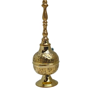 Op de afbeelding: Een gouden metalen decoratieve spuitfles met een versierd ontwerp. De fles heeft een rond lichaam met een lange, slanke hals en een kleine, ronde basis.