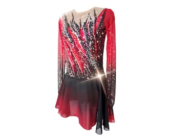 Peut inclure: Une robe de patinage artistique rouge et noire à manches longues et une jupe noire. Le corsage présente un motif de flammes noires et rouges avec des strass. La jupe est noire avec un effet dégradé rouge.