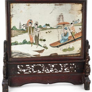 May include: A rectangular table screen featuring a painted glass panel set in a dark wood frame. The painting depicts two figures standing on a shore and two figures in a small boat on a lake, with a pagoda and trees in the background.