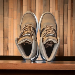 May include: A pair of brown high-top trainers with black accents and white text that reads "PRAOTOAL".