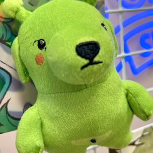 May include: A white ceramic mug with a black handle and the text "But First, Coffee" in a black, handwritten-style font. The mug is on a white surface.