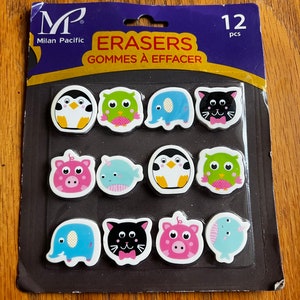 May include: A package of 12 colorful animal-shaped erasers. The erasers are in a clear plastic package with a blue and gold background. The package says "Erasers Gommes à Effacer" and "Milan Pacific" on it.