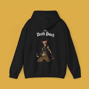 May include: Black hoodie with the text "FIVE FINGER Death Punch" in white gothic lettering. The back of the hoodie features a graphic of a horned figure holding a weapon. The hoodie has a hood and a front pocket.