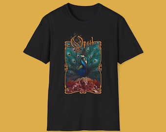 Könnte beinhalten: Schwarzes T-Shirt mit einem Grafikdruck eines Pfaus mit ausgebreiteten Federn. Die Grafik ist in Gold gerahmt und trägt den Schriftzug "Opeth" in einer stilisierten Schrift.