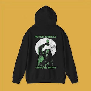 May include: Black hooded sweatshirt with a green graphic print of a monster holding a glass of beer. The graphic also includes the text "Peter Steele Tribute Night" and "Duff's Brooklyn".