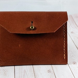 Cartera de cuero con tachuelas y botones cosidos a mano