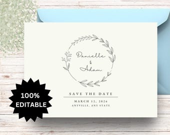 Könnte beinhalten: Eine weiße Save-the-Date-Karte mit einem schwarzen floralen Kranz und dem Text "Danielle & Adam" in einer handschriftlichen Schriftart. Das Datum "12. März 2026" und der Ort "Anyville, Any State" sind unter dem Kranz gedruckt.