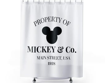 Puede incluir: Cortina de ducha blanca con texto negro que dice "PROPERTY OF MICKEY & Co. MAIN STREET, USA 1928" y una silueta negra de la cabeza de Mickey Mouse.