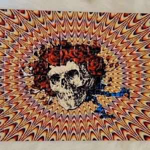 May include: A colorful jigsaw puzzle featuring a psychedelic image of a skull with flowers. The background is a swirling pattern of orange, yellow, and purple.