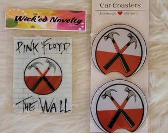 May include: Two white and orange car coasters with a black and white image of two crossed hammers. The coasters are labeled "Car Coasters" and "Handmade with love".