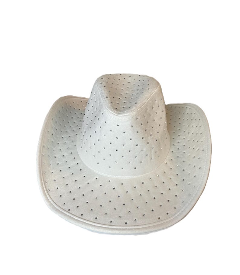 May include: White cowboy hat with a perforated design. The hat features a wide brim and a rounded crown. Small, evenly spaced holes cover the entire hat, adding a decorative element. The hat is made of a smooth material.