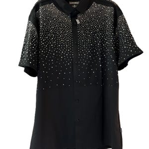 Può includere: Camicia nera a maniche corte con bottoni, impreziosita da scintillanti strass che scendono sul davanti. La camicia ha un colletto classico e il marchio "BARABAS" è visibile.