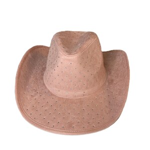 May include: A blush-colored cowboy hat with a suede-like texture. The hat is adorned with small, evenly spaced rhinestones across the crown and brim. The hat has a classic cowboy hat shape with a rounded crown and a wide, curved brim.