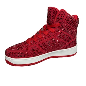 Puede incluir: Zapatillas rojas de caña alta con suela blanca y cubiertas de pedrería roja.