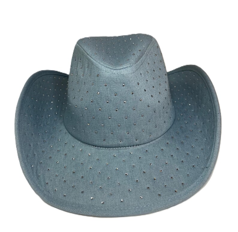 May include: A light blue cowboy hat with a wide brim and a rounded crown. The hat is covered in small, sparkling rhinestones. The hat is made of a soft, denim-like material.