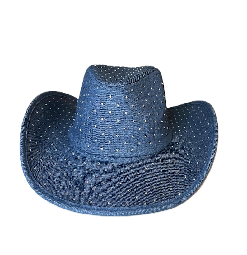May include: A denim cowboy hat with a wide brim and a crown. The hat is a medium blue color and is covered in small, silver-colored rhinestones. The hat is a classic Western style.