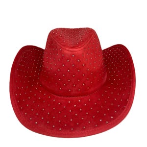 May include: A red cowboy hat with a velvet texture and small, silver-colored embellishments. The hat has a classic western design with a wide brim and a rounded crown. This hat is a stylish accessory.