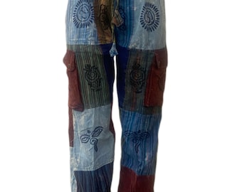 May include: Patchwork pants with a drawstring waist. The pants feature a mix of blue, burgundy, and tan patches with embroidered designs. The pants have two pockets and are displayed on a mannequin.