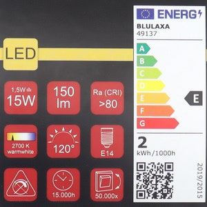 Pode incluir: Etiqueta de efici&ecirc;ncia energ&eacute;tica para uma l&acirc;mpada LED. A etiqueta mostra que a l&acirc;mpada &eacute; classificada como E, consome 15 watts, tem uma sa&iacute;da de luz de 150 l&uacute;mens, uma temperatura de cor de 2700K (branco quente), um &acirc;ngulo de feixe de 120 graus e um tamanho de base E14. A etiqueta tamb&eacute;m mostra que a l&acirc;mpada tem uma vida &uacute;til de 15.000 horas e &eacute; regul&aacute;vel.