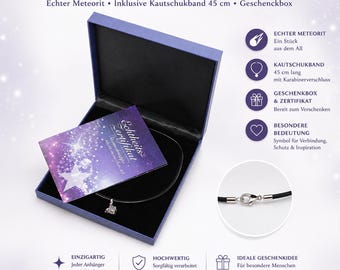 Może przedstawiać: Wisiorek z meteorytem z małym, metalicznym kamieniem o nieregularnym kształcie na czarnym gumowym sznurku. Zestaw zawiera ciemnoniebieskie pudełko prezentowe, certyfikat autentyczności oraz zapięcie typu karabińczyk.