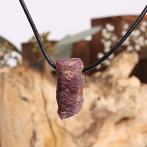 Ruwe robijn hanger – Natuurlijke edelsteen ca. 22 x 10 mm, geboord, met leren koord en organza zakje, uniek sieraad