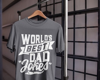 May include: A dark gray t-shirt with a white graphic that says "World's Best Dad Jokes".