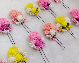 May include: Assortment of floral hair pins with pink, yellow, and white flowers. The pins have two prongs and are perfect for adding a touch of elegance to any hairstyle.