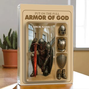 May include: A framed artwork featuring a kneeling knight with a glowing red sword. The text reads "PUT ON THE FULL ARMOR OF GOD" and "YOUR NAME". Additional images of armor pieces are displayed.