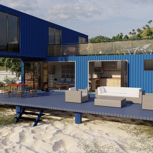 A blue container home with a wooden deck and patio furniture. The home has a large window and a glass door leading to the interior. The deck is made of wood and has a railing. The patio furniture includes a white couch, two armchairs, and a coffee table. The home is situated on a sandy beach with green grass and palm trees in the background. The text 'Oasis Container Living' is visible on the side of the home.
