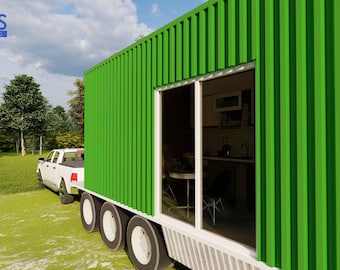 May include: A green shipping container home with a large window revealing a kitchen interior. The home is being towed by a white pickup truck on a grassy lawn.