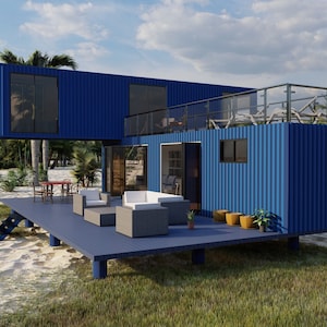 Render of a pre-engineered shipping container home (C1), showcasing a sustainable, modern, and minimalist design, perfect for a tiny modular metal home. A blue container home with a wooden deck and a balcony. The home is situated on a sandy beach with green grass and palm trees in the background. The home has large windows and a glass railing on the balcony. The text 'Oasis Engineering' is visible in the top right corner of the image.