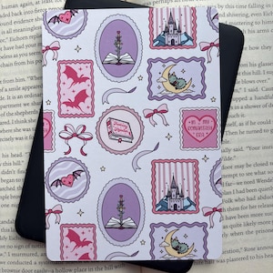 May include: A rectangular sticker featuring a repeating pattern of pink and purple illustrations including castles, swords in books, dragons on moons, winged hearts, and a heart-shaped label with the text "IN MY ROMANTASY ERA" and bows.
