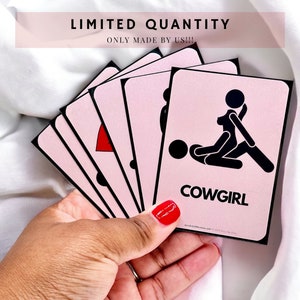 Everything But Missionary - Limited Quantity Sex Position Cards, held by the creator. Top card displays the "cowgirl" position, using stick figures.