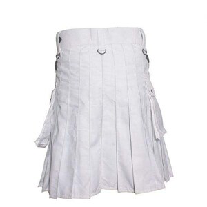 K&ouml;nnte beinhalten: Ein wei&szlig;er Utility-Kilt mit mehreren Taschen und einem plissierten Design. Der Kilt hat ein schwarzes Schnallen- und Riemendetail.