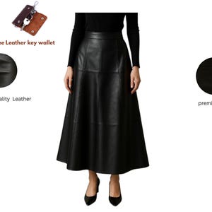 May include: A long, black leather skirt with a flared silhouette. The skirt is shown on a person wearing a black top and black heels. The image also includes a free leather key wallet.