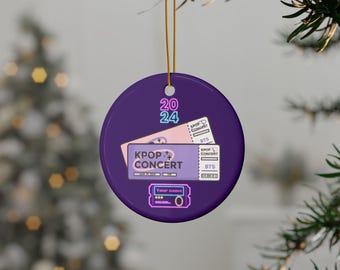May include: Purple round Christmas ornament with a design of two concert tickets for a KPOP concert. The tickets have the text "KPOP CONCERT" and "BTS". The ornament also has the text "2024" and "Your name" on it.