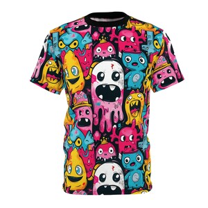 May include: A short-sleeved t-shirt featuring a vibrant, all-over print of colorful cartoon monsters. The design includes various shapes and sizes of monsters in shades of pink, yellow, blue, and white against a black background. The shirt has a black collar.