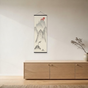 Peut inclure: Une tenture murale verticale en forme de rouleau présentant une peinture à l'encre minimaliste de montagnes, d'une cascade et d'un petit bateau sur l'eau. L'œuvre comprend un soleil rouge et un sceau carré rouge avec le kanji de montagne.