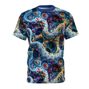 May include: A short-sleeved t-shirt with a striking, all-over print. The design is an intricate abstract pattern of swirling, tentacle-like forms in blue, orange, and yellow. The shirt has a blue collar, and the overall effect is visually dynamic and eye-catching.