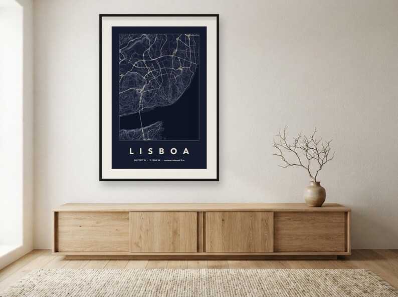 May include: A framed wall art print featuring a dark blue map of Lisbon with white street lines and topographic contours. The text LISBOA is printed in white capital letters below the map, followed by geographic coordinates in small text.