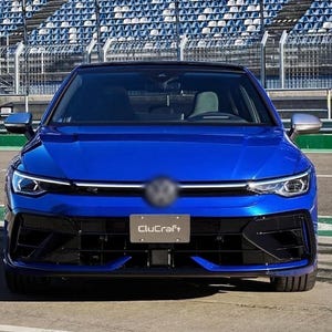 May include: A bright blue hatchback car viewed from the front, featuring a black grille, sharp LED headlights, and a number plate displaying the text CluCraft. The vehicle has a sleek bonnet design and silver side mirrors, positioned on a track.