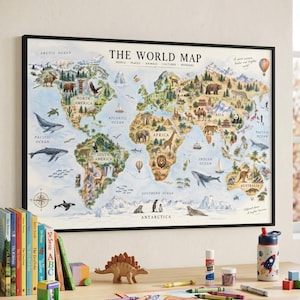 May include: A framed wall map titled THE WORLD MAP featuring colorful illustrations of animals, landmarks, and oceans across continents. The map includes text labels for oceans and continents, set in a black frame on a light-colored wall.