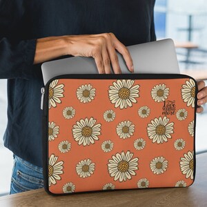 Könnte beinhalten: Orangefarbene Laptoptasche mit einem weißen Gänseblümchenmuster und dem Text "Love yourself more".
