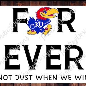 Op de afbeelding: Een wit bord met zwarte tekst die "FOR EVER NOT JUST WHEN WE WIN" luidt. Een blauw en geel mascotte met de letters "KU" op zijn borst bevindt zich boven het woord "FOR".