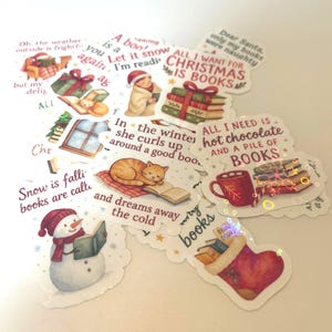 Könnte beinhalten: Eine Sammlung skurriler Aufkleber mit Winter- und Buchmotiven. Die Aufkleber zeigen Illustrationen eines Schneemanns, einer lesenden Katze, Bücherstapel und Texte wie "Alles, was ich zu Weihnachten will, sind Bücher."