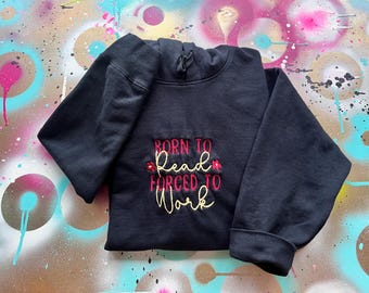 May include: Black hooded sweatshirt with the embroidered text "Born to Read, Forced to Work" in red and yellow thread.